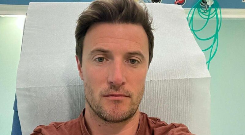 Homem sentado em uma consulta médica, olhando preocupado, simbolizando a luta contra o câncer relacionado ao HPV.